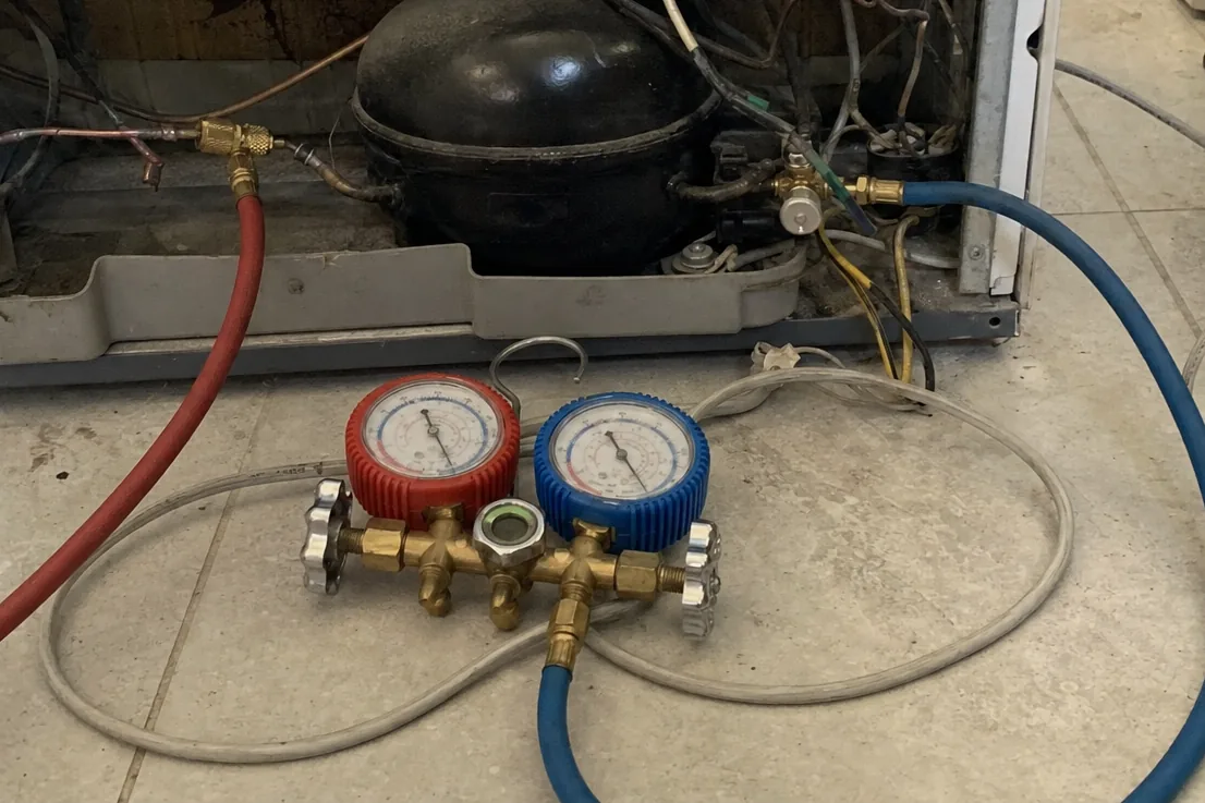 The exposed compressor and line set of a built-in appliance, service hoses connected